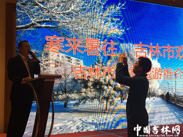中国吉林网记者（右）在推介会现场抓拍每一个瞬间
