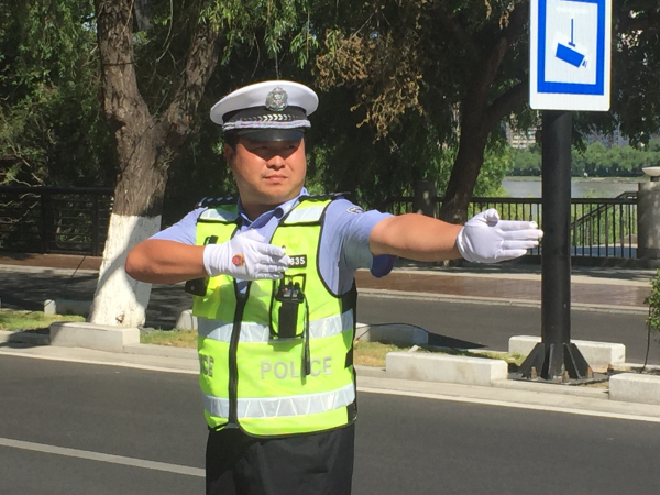 图为船营交管大队二中队民警张宝平在烈日下指挥交通.